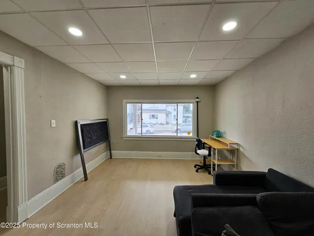 a living room with furniture gym equipment and a large window