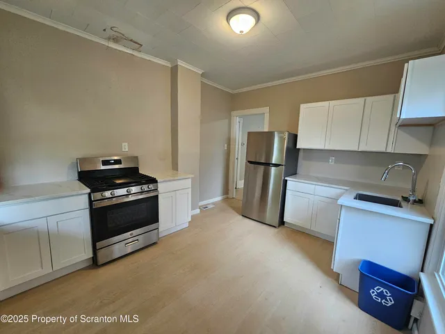 a kitchen with refrigerator a stove and a sink