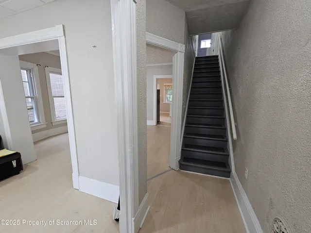 a view of a hallway with wooden floor and entryway