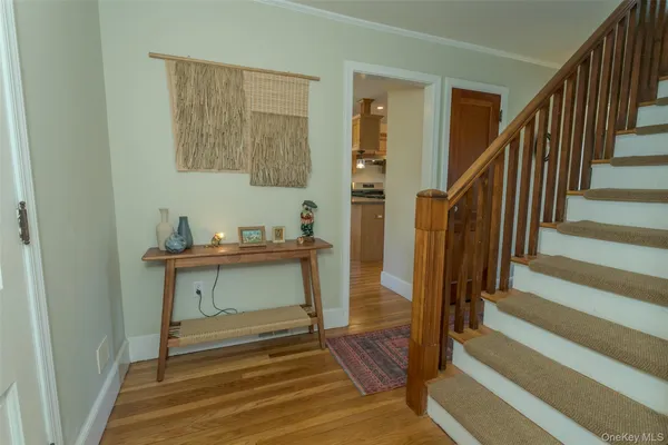 a view of entryway and hall with wooden floor