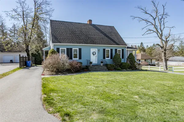 a front view of house with yard and trees around