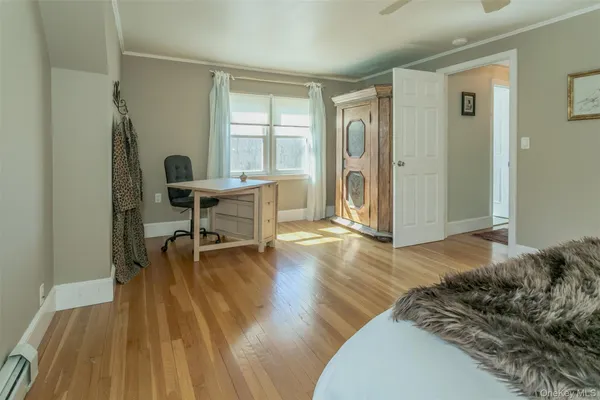 a view of a workspace with wooden floor and a window