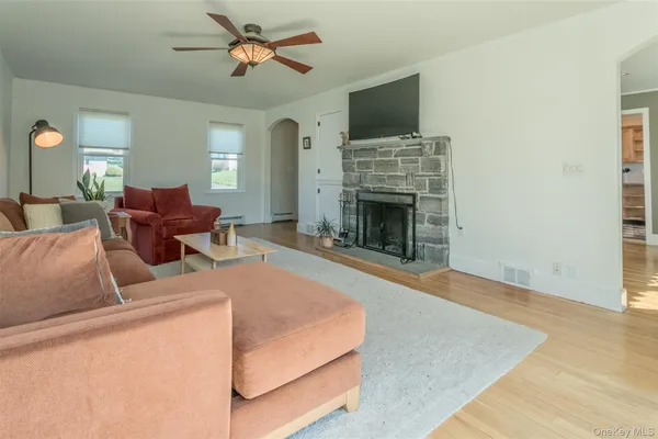 a living room with furniture a flat screen tv and a fireplace