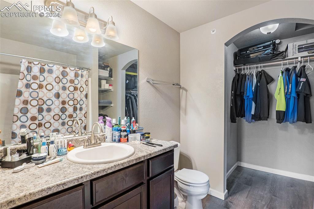 4346 Yellow Dock Point Colorado Springs, CO 80911 - Photo 11 of 20 a bathroom with a granite countertop sink a toilet and a mirror