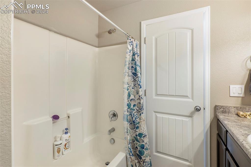 4346 Yellow Dock Point Colorado Springs, CO 80911 - Photo 15 of 20 a bathroom with a shower curtain and a sink