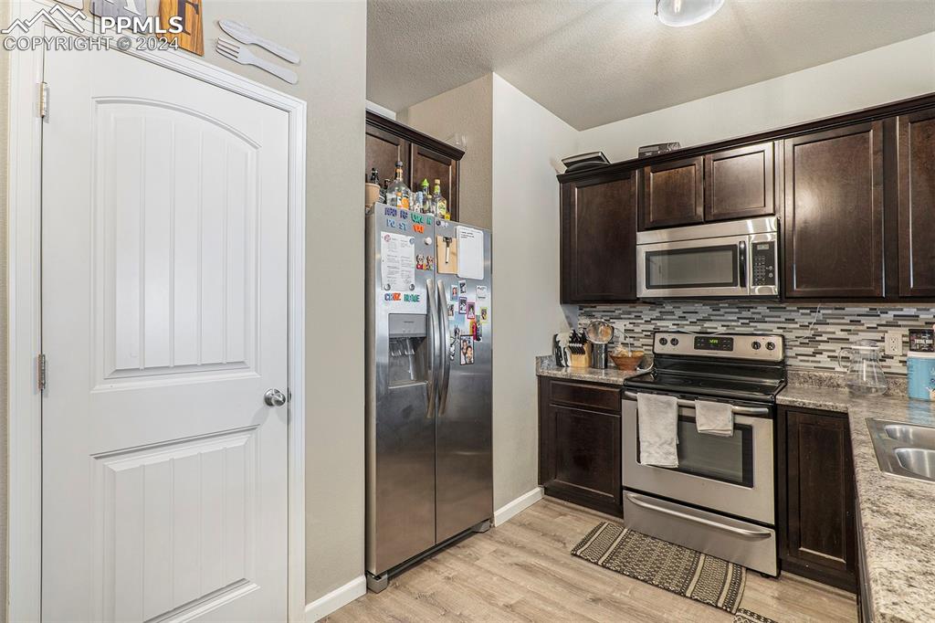 4346 Yellow Dock Point Colorado Springs, CO 80911 - Photo 6 of 20 a kitchen with stainless steel appliances granite countertop a refrigerator and a stove top oven