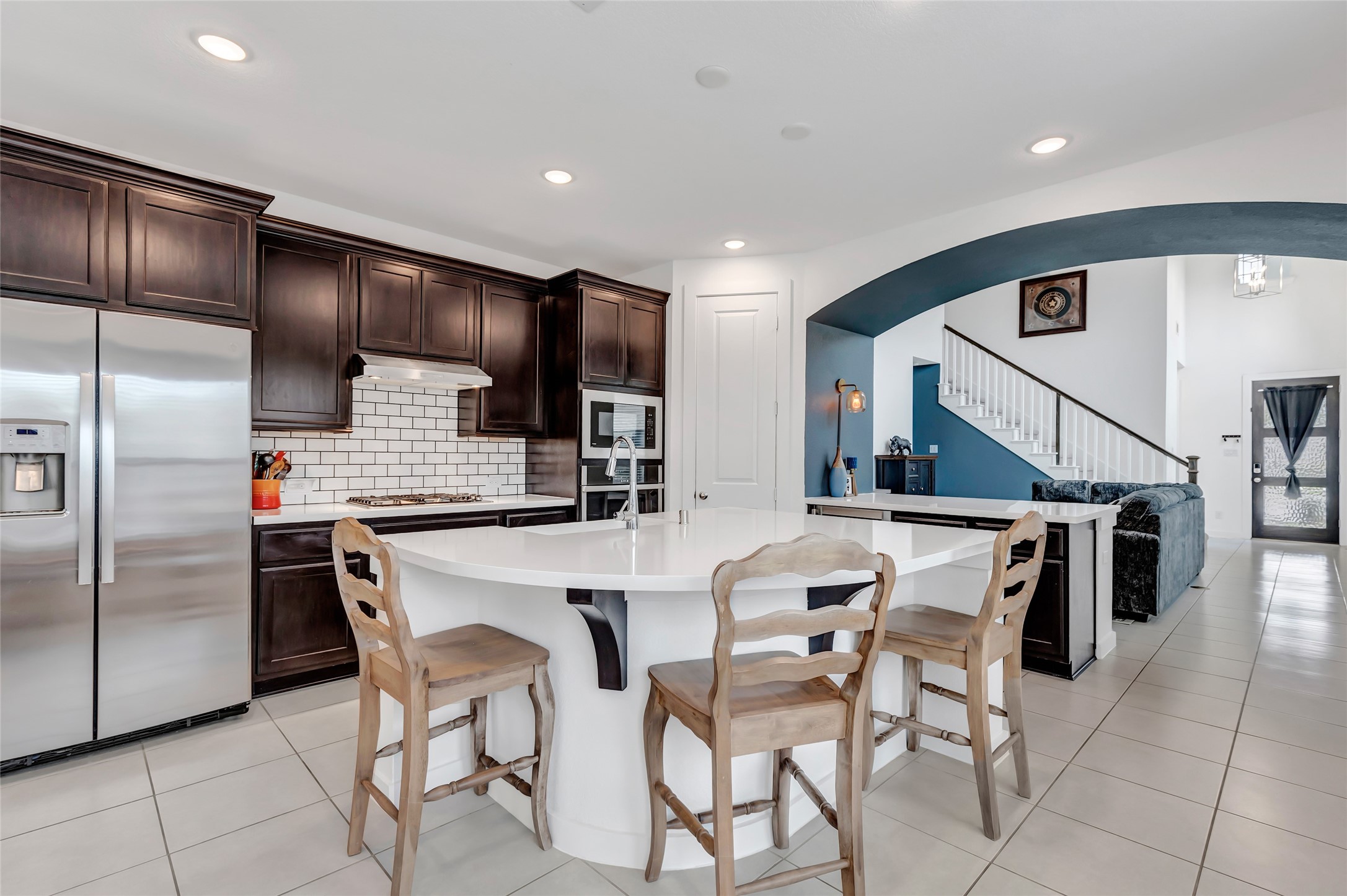 527 Chestnut Reef Court Conroe, TX 77304 - Photo 15 of 40 a kitchen with stainless steel appliances kitchen island granite countertop a refrigerator a stove a microwave oven with white cabinets and chairs