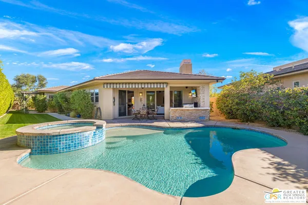 a view of a house with swimming pool and sitting area