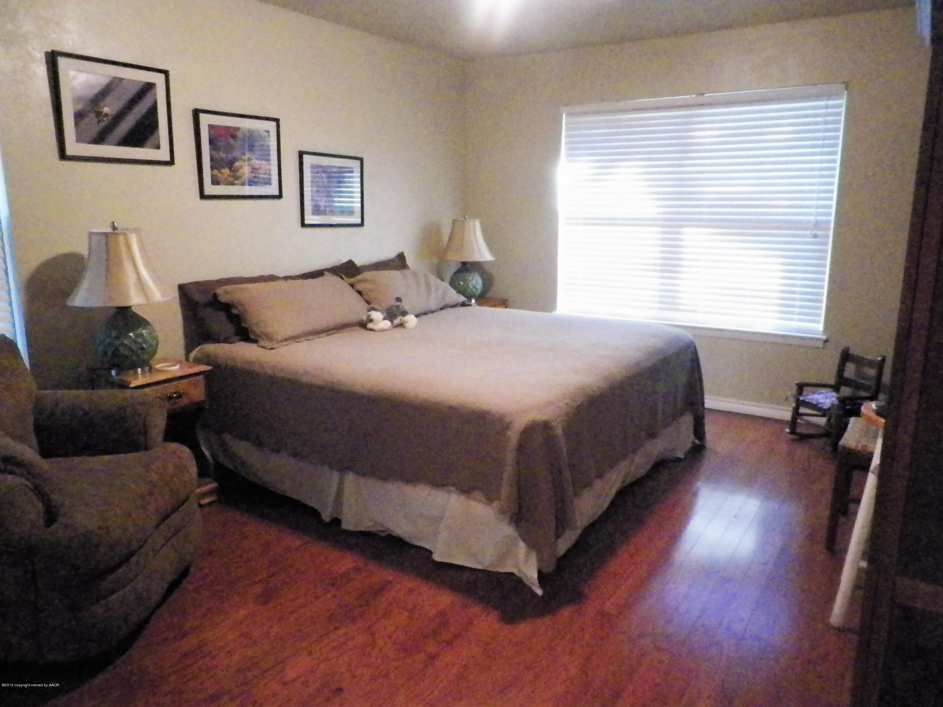 7100 Jameson Road Amarillo, TX 79106 - Photo 5 of 6 a bedroom with a bed and wooden floor