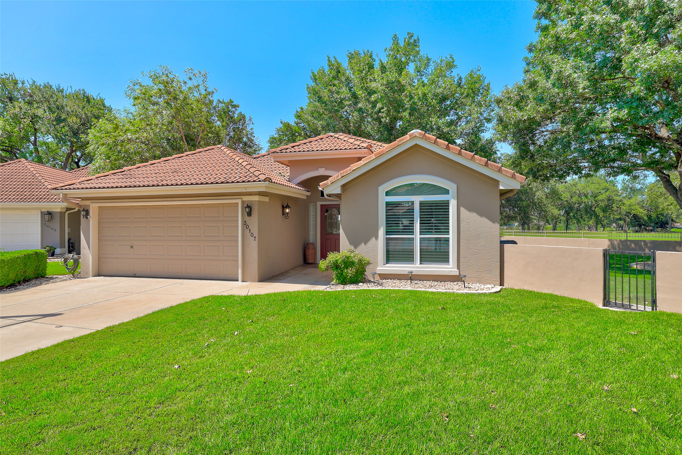30107 Hamlet Circle Georgetown, TX 78628 - Photo 1 of 40 A well-kept yard presents a charming residence with a tile roof and attached garage.