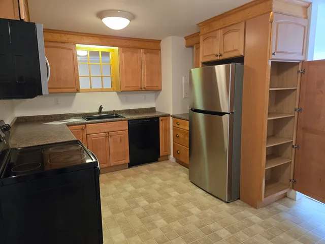 a kitchen with stainless steel appliances granite countertop a refrigerator a stove a sink and a microwave