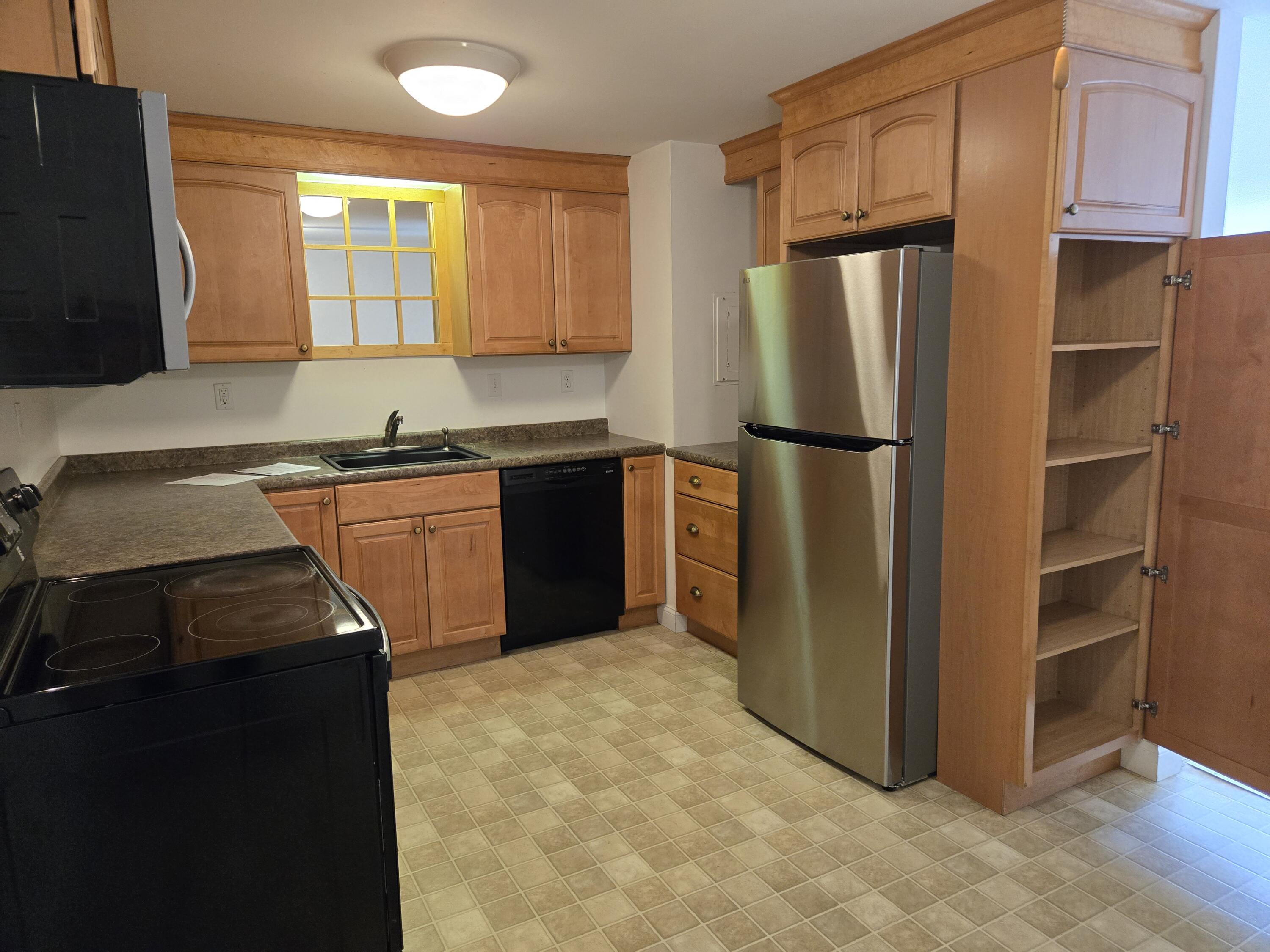 a kitchen with stainless steel appliances granite countertop a refrigerator a stove a sink and a microwave