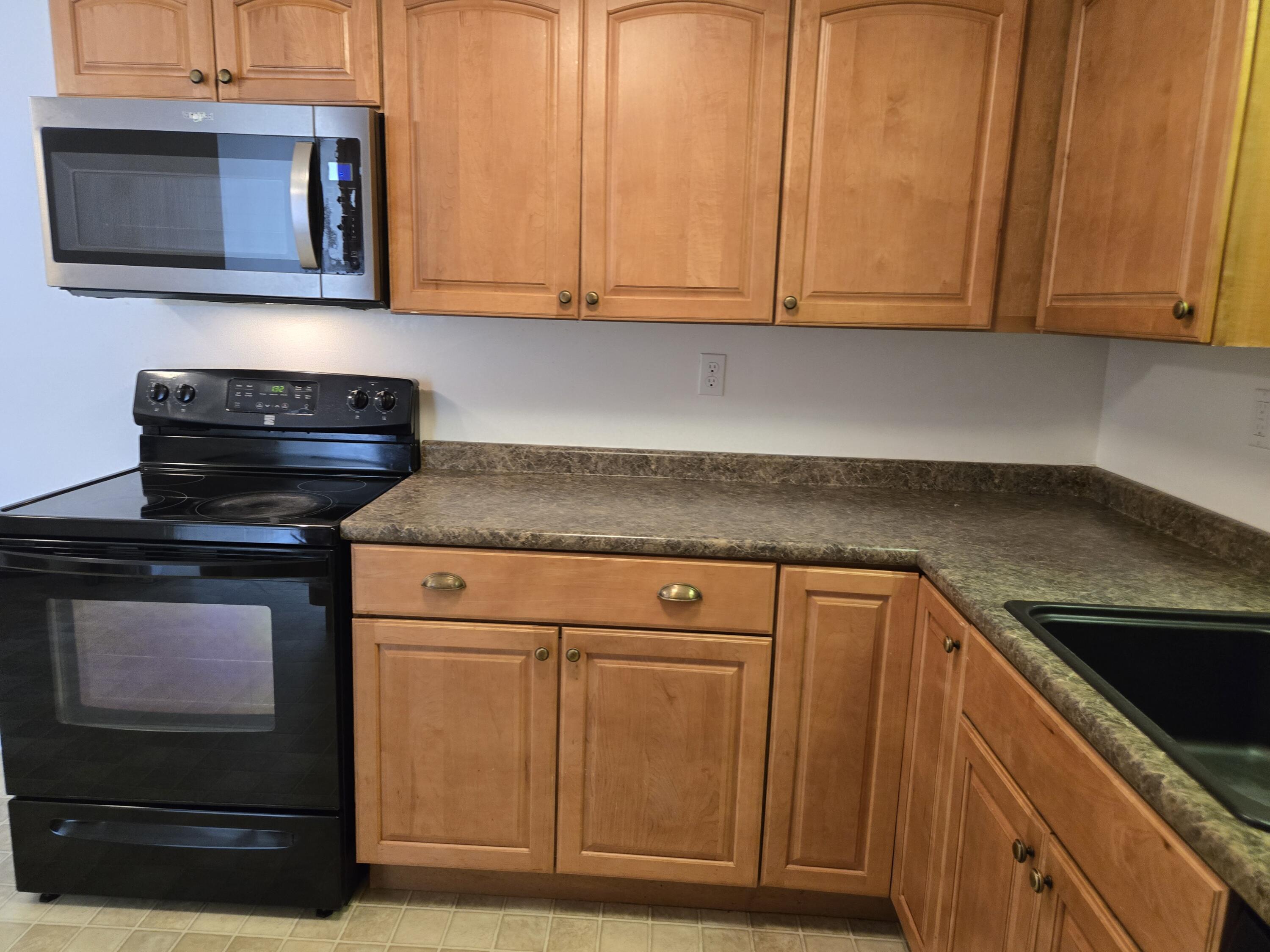 307 West Main Street, Unit 7 Hyannis, MA 02601 - Photo 3 of 15 a kitchen with wooden cabinets and a stove top oven