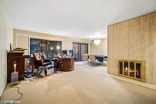 a view of a livingroom with workspace and a fireplace