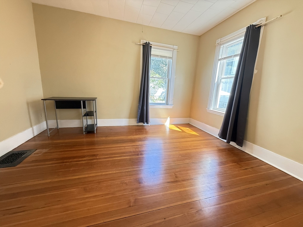 53 Litchfield Street, Unit 53 Boston, MA 02135 - Photo 4 of 14 a view of an empty room with wooden floor and a window
