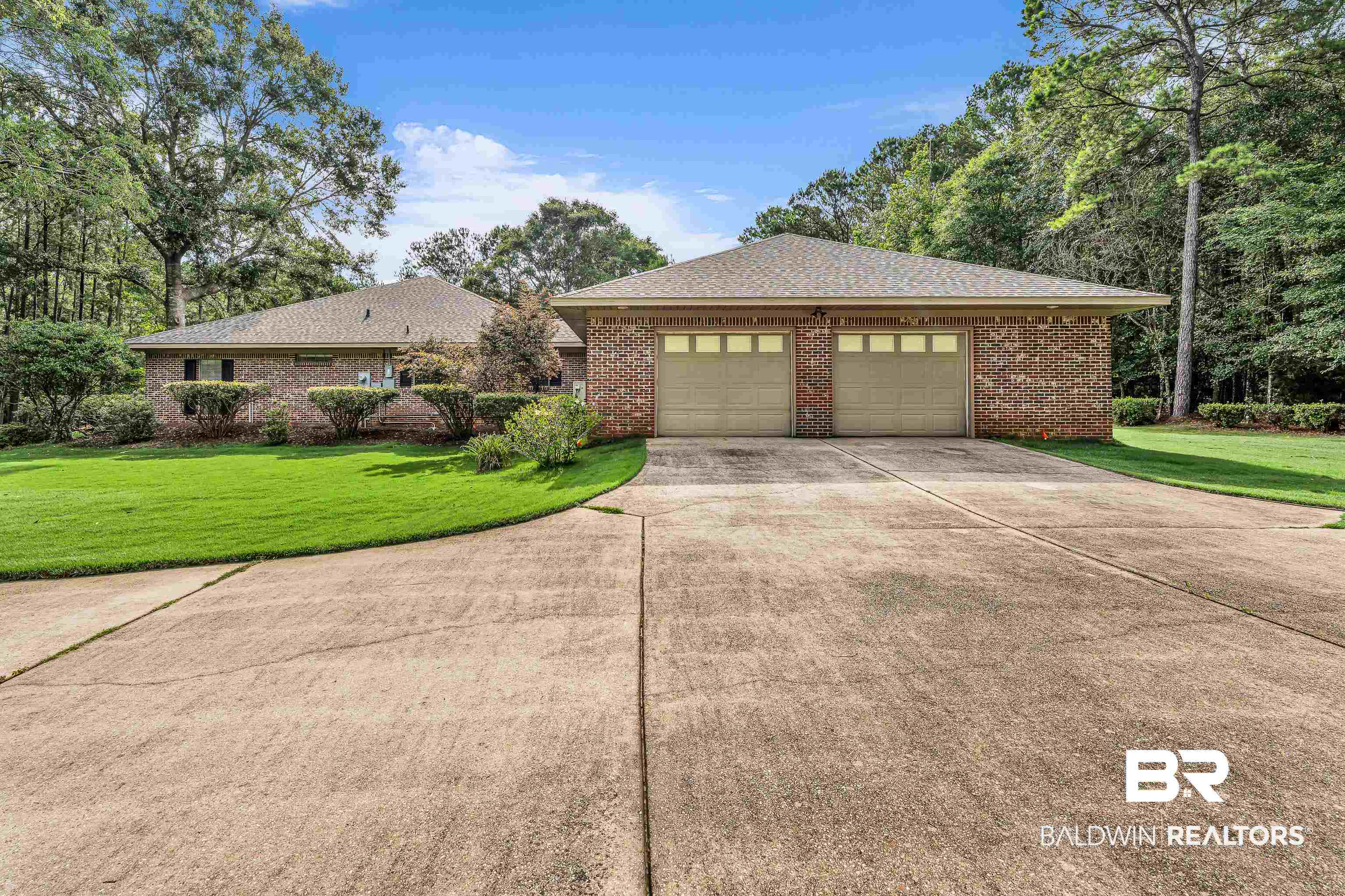 7014 Blakeley Road Daphne, AL 36527 - Photo 6 of 45 Brick exterior featuring a two-car garage with panel doors and window inserts