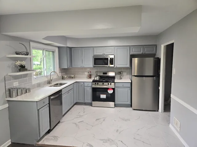 a kitchen with granite countertop a refrigerator stove and sink