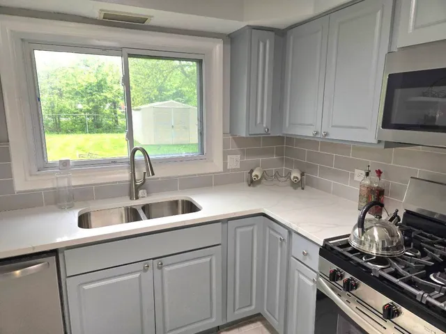 a kitchen with a sink stove top oven and cabinets