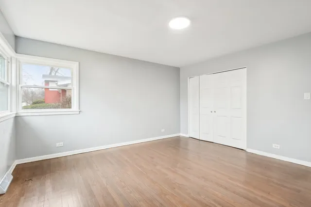 an empty room with wooden floor and window