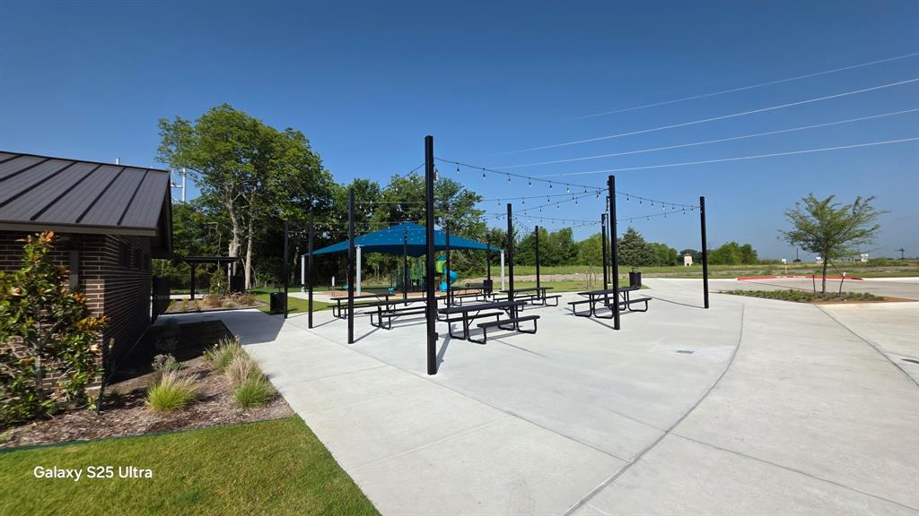 1614 Potomac Lane Blue Ridge, TX 75424 - Photo 15 of 18 Outdoor gathering area featuring multiple picnic tables, strung lighting, and a shaded canopy