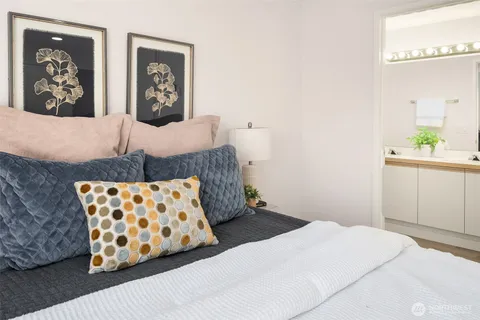a bedroom with a bed and painting on the wall