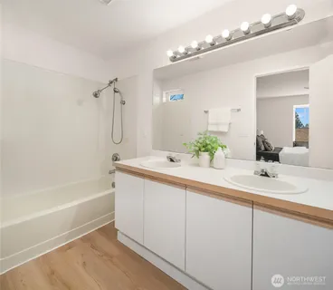 a bathroom with a tub sink and mirror