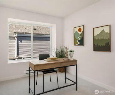 a view of a workspace room with furniture and window