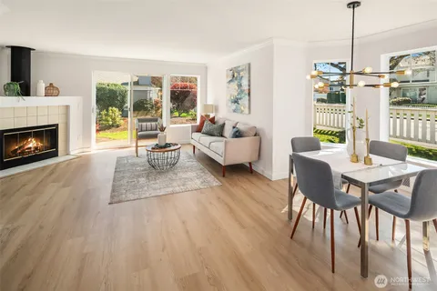 a living room with furniture a fireplace and a floor to ceiling window