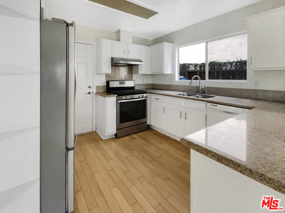 15232 Foothill Boulevard, Unit 111 Sylmar, CA 91342 - Photo 4 of 19 a kitchen with granite countertop a sink appliances cabinets and counter space