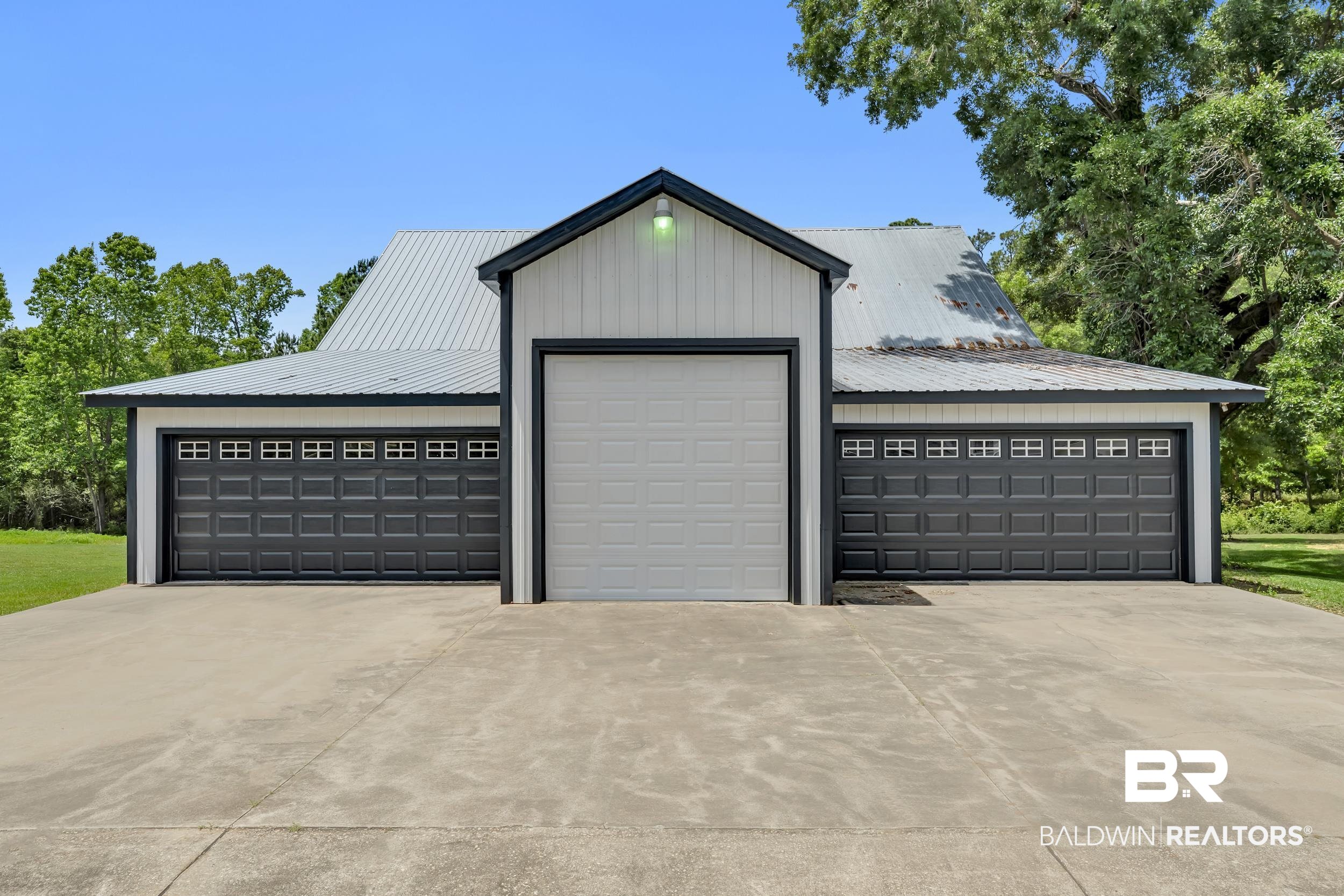 43199 Pine Grove Road Bay Minette, AL 36507 - Photo 11 of 71 Three-bay garage structure featuring a central white overhead door and two charcoal gray overhead doors