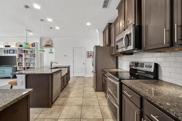 a kitchen with stainless steel appliances granite countertop a sink stove and refrigerator