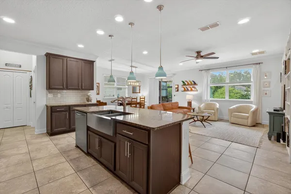 a kitchen with stainless steel appliances granite countertop a sink counter space cabinets and a view of living room