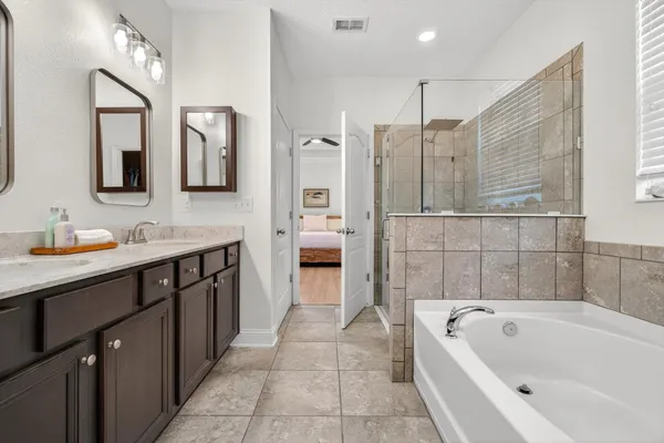 a bathroom with a tub a sink and mirrors