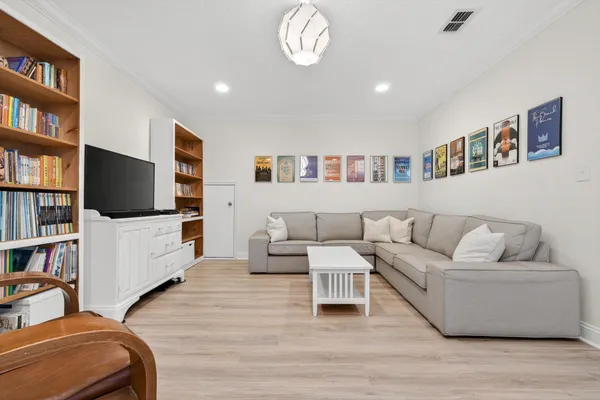 a living room with furniture a flat screen tv and kitchen view