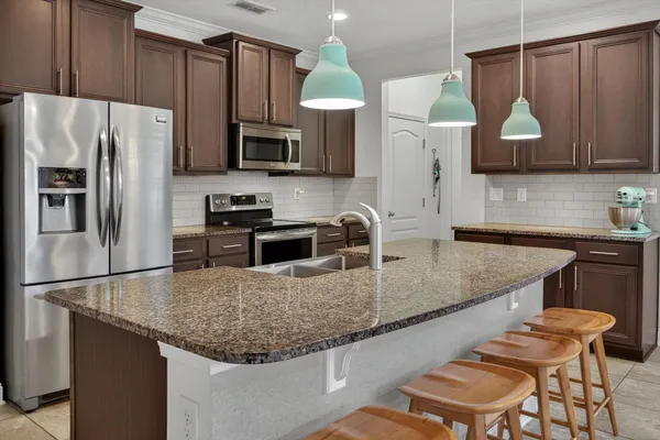 a kitchen with stainless steel appliances granite countertop a sink refrigerator and microwave