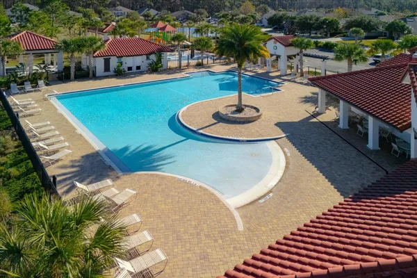 an aerial view of a tennis ground with a water fall and palm trees