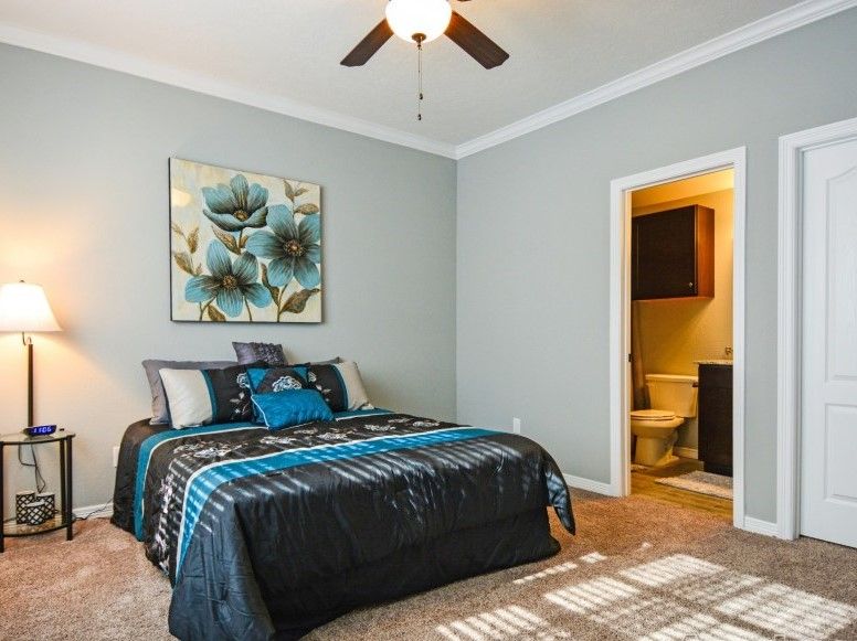 301 Southwest Parkway, Unit 314 College Station, TX 77840 - Photo 8 of 14 a bedroom with a bed and a chandelier