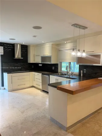 a kitchen with stainless steel appliances granite countertop a refrigerator and a stove