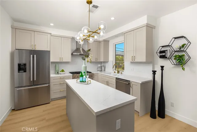 a kitchen with kitchen island white cabinets and stainless steel appliances