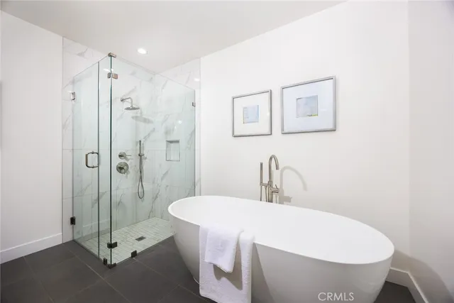 a bathroom with a white tub shower vanity and a sink