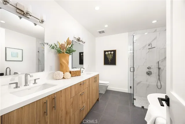 a bathroom with a double vanity sink mirror and shower