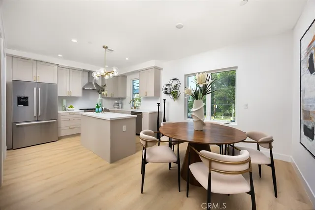 a kitchen with a dining table chairs and refrigerator