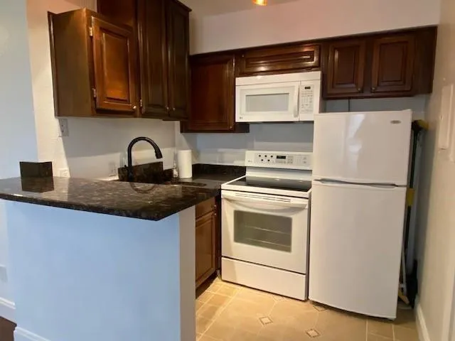 a kitchen with a refrigerator sink and cabinets