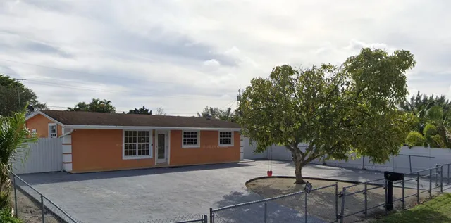 a backyard of a house with table and chairs