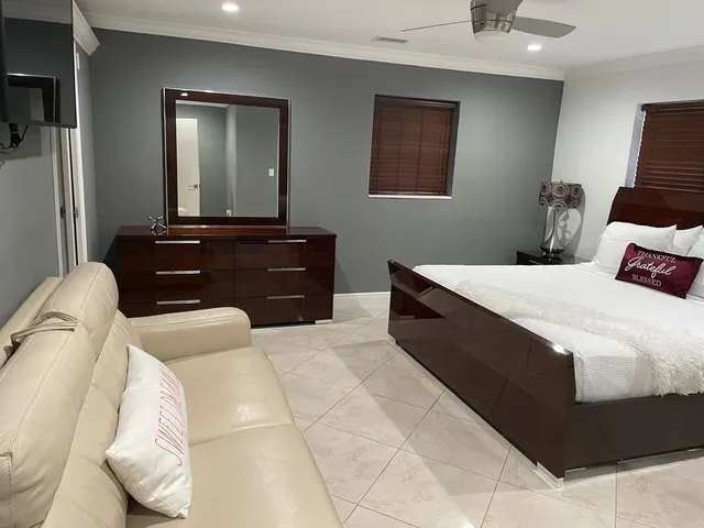 a bedroom with a bed and a mirror on dresser