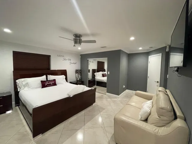 a large bedroom with a bed and a flat screen tv
