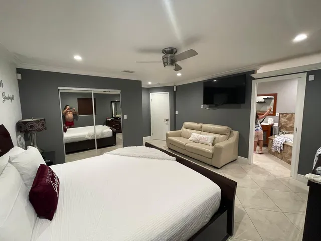 a bedroom with bed and large mirror