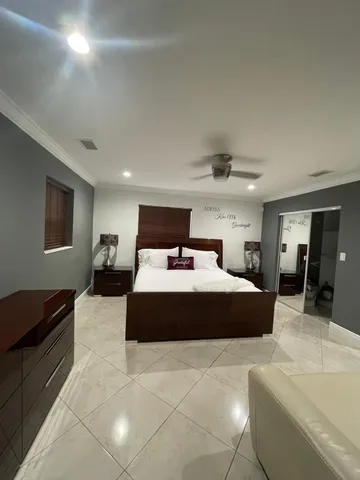 a spacious bedroom with a bed a table and a dresser