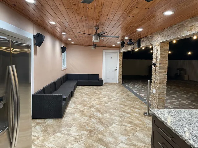 a kitchen with stainless steel appliances granite countertop a refrigerator a sink a stove and a refrigerator