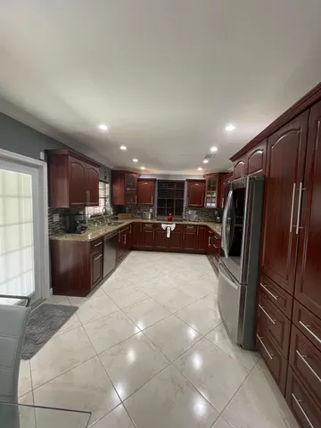 a large kitchen with a large counter top stainless steel appliances and cabinets